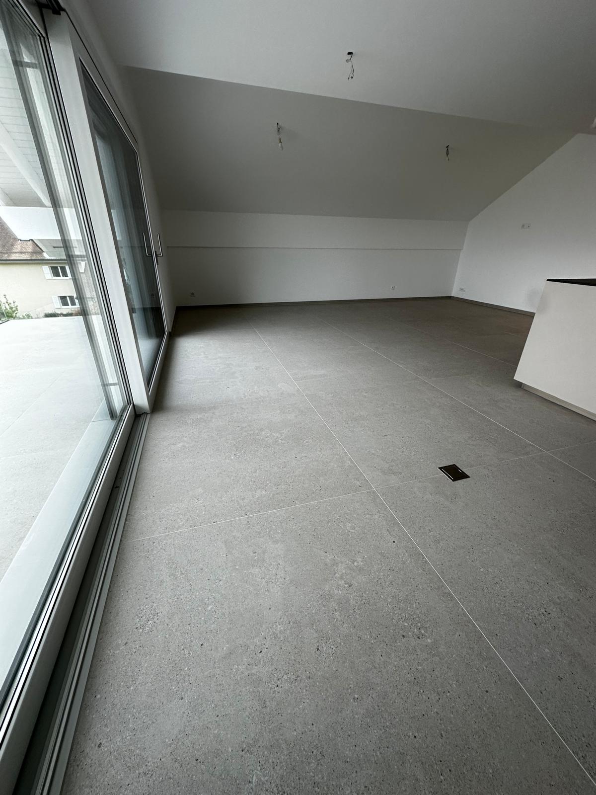 Carrelage 120x120 posé dans le salon, joints minimalistes